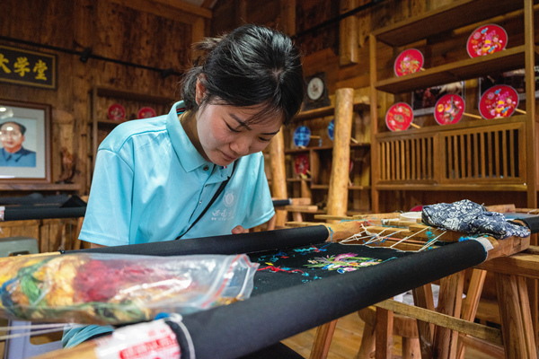 小分隊成員在苗繡工坊體驗繡制酉州苗繡。西南大學供圖