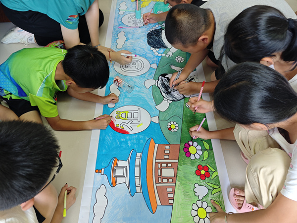 服務團成員與孩子們一起手繪表白祖國。重慶郵電大學供圖
