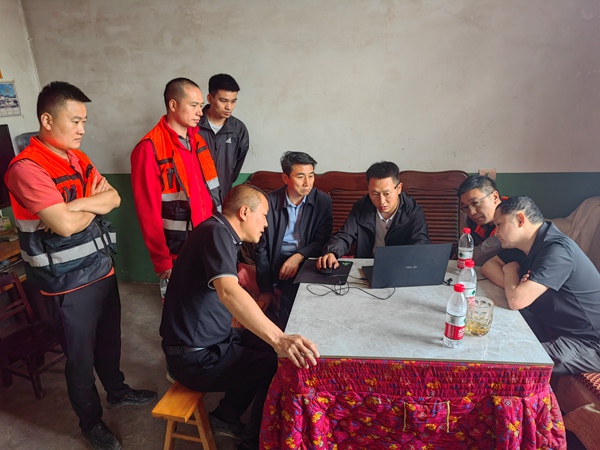 《緊急磋商》。5月8日，南川區山王坪鎮山王坪村3組發生滑坡險情，南川區規劃和自然資源局地環站站長張旭（右二）、南川區規劃和自然資源局副局長王江海（右四）、山王坪鎮鎮政府副鎮長王勇（右五）、地質災害先期處置專家胡明軍（左二）及駐守隊員等有關人員在現場開緊急磋商會議。李鋒俊攝