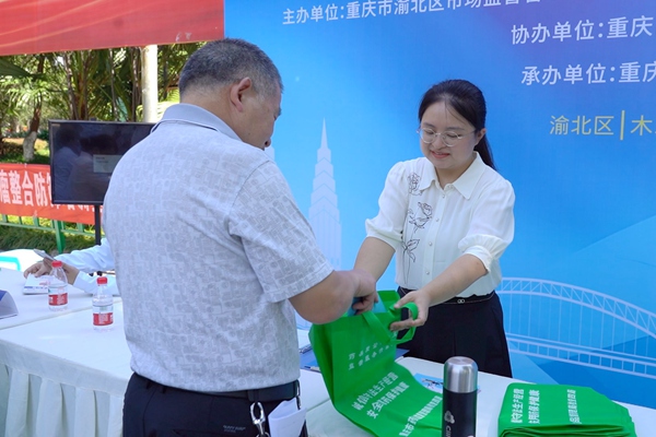 村民領取宣傳資料。渝北區市場監管局供圖