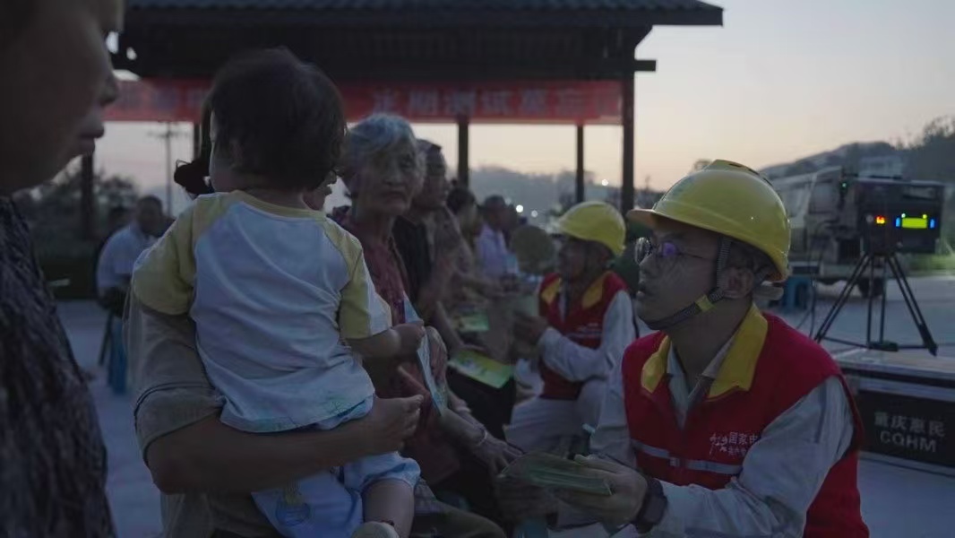 電力員工向村民發放節能宣傳資料。國網重慶永川供電公司供圖