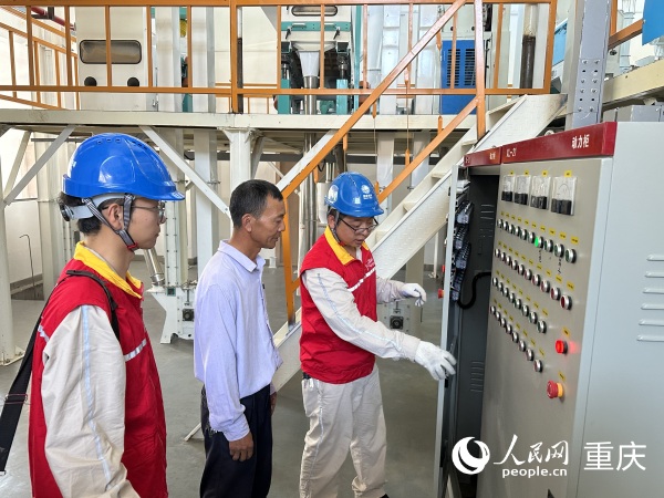 供電所工作人員上門檢查小米加工廠用電情況。人民網記者 劉政寧攝