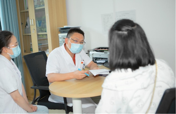 王敏建正在指導患者家長如何與孩子溝通。重慶市精神衛生中心供圖