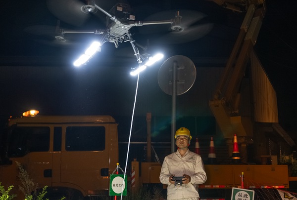 工作人員操作無人機配燈為不停電作業照明。國網重慶永川供電公司供圖