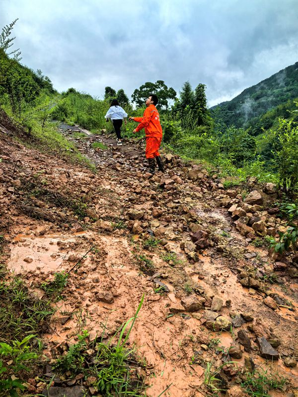 《雨后地災巡查》。7月11日，巫山縣銅鼓鎮副鎮長溫利華、地質駐守工程師王忠凌（右）雨后巡查銅鼓村柏果樹坪地災點。劉勇攝