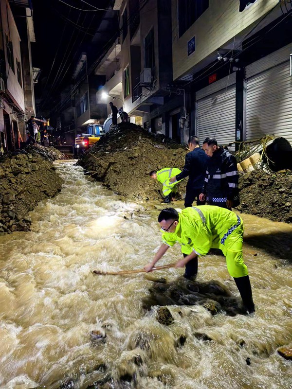 《連夜排險》。7月11日，巫溪縣田壩鎮場鎮老街發生泥石流，導致涵洞堵塞，泥石流碎渣可能形成堰塞湖淹沒場鎮老街住戶，造成次生災害，情況十分緊急。當日21時，鎮機關黨員干部帶隊，會同受災群眾，在機械設備的幫助下開挖臨時排水溝，排除險情。張華攝