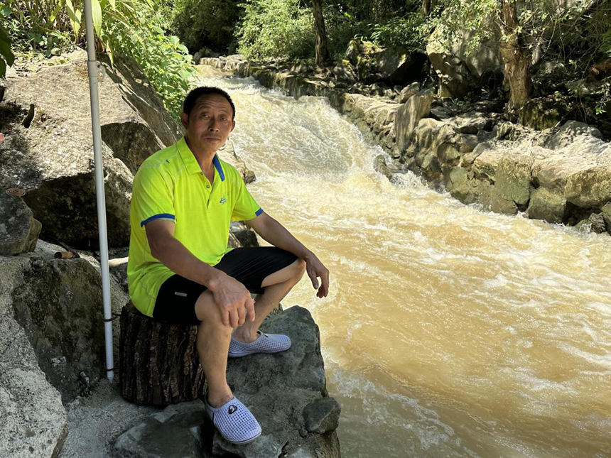 向立財守在溪流邊負責船只轉運。黃亞輝攝