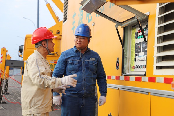 國網重慶永川供電公司（左）和國網安徽省電力有限公司（右）工作人員通力合作。國網重慶永川供電公司供圖