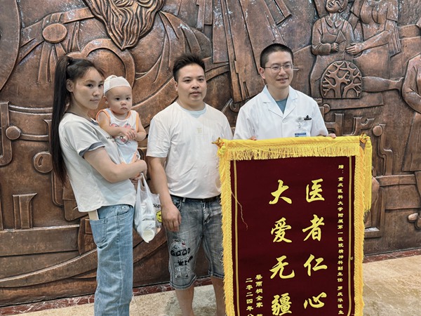 蔡忠帶著妻兒，為羅醫生送來錦旗。朱雋攝