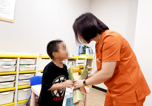 孩子給老師送上鮮花。重慶小米熊兒童醫院供圖