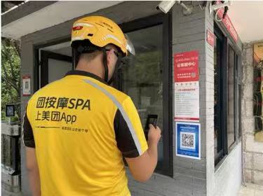 騎手在小區入口處掃碼可一鍵登記快捷通行。金科服務供圖