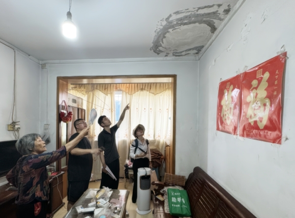九龍坡區審計局工作人員走進居民家中，了解老舊小區改造情況。九龍坡區審計局供圖