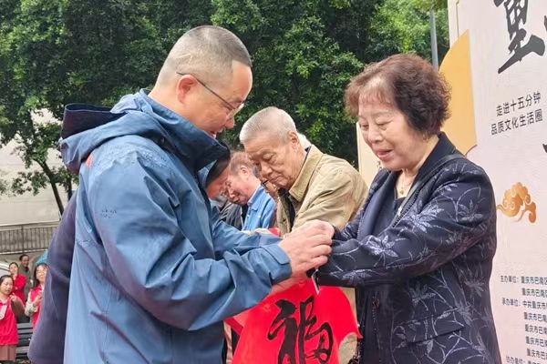 向社區老人送出健康監測“愛心手環”。胡超攝