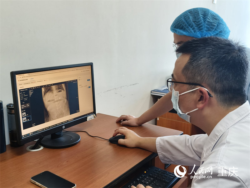 重慶醫科大學附屬兒童醫院兩江院區，醫生們通過醫檢互認系統查看患兒在當地的檢查結果。人民網 陳琦攝