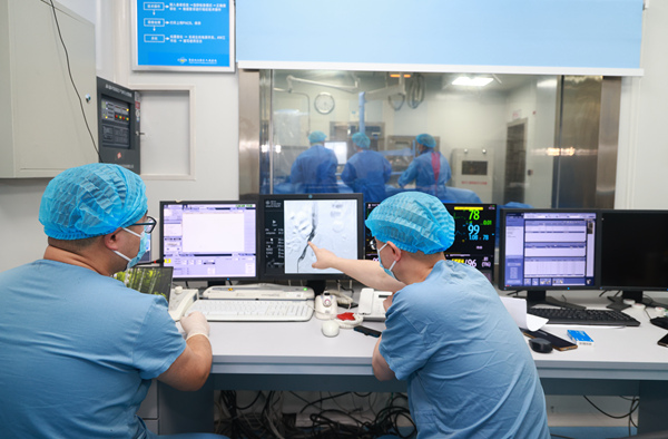 醫生在手術室外實時監控介入手術進行情況。曾英豪攝