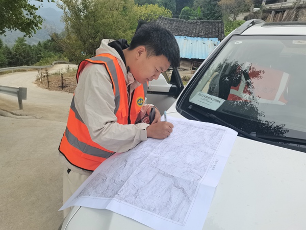 《爭分奪秒》。10月5日，川東南地質大隊在黔江區金洞鄉魚泉村開展黔江南部片區1：10000小流域地質災害精細化調查評價。圖為年輕的地質工程師況星麟爭分奪秒進行野外地質填圖。徐騰蛟攝