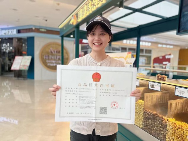 展示食品經營許可證。李靜攝