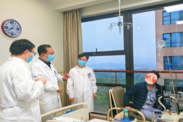 術后查房時，李明正在看書。重慶醫科大學附屬第二醫院供圖