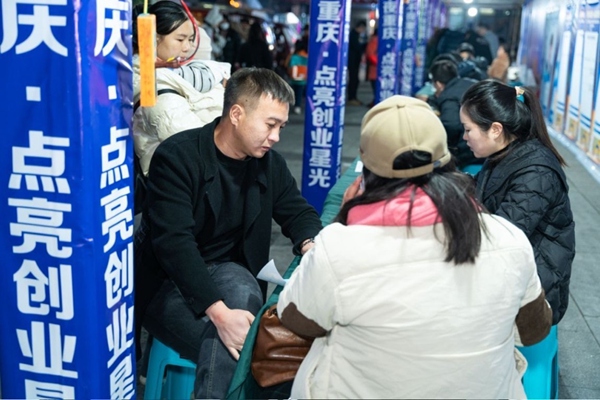 企業招聘攤位前，企業工作人員與求職者進行面談。重慶市人力社保局供圖