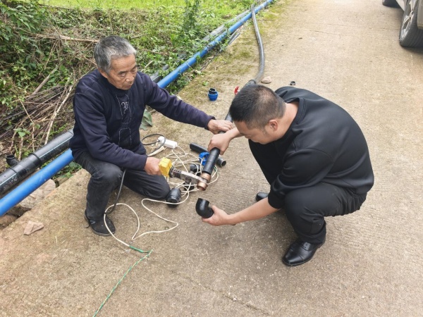 三匯口鄉大石社區網格員徐勇正在幫居民維修水。三匯口鄉供圖