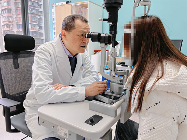 范光忠為患者檢查視力情況。重慶普瑞眼科醫院供圖