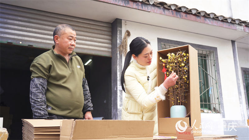 鄧紀會正在檢查制作完成的蠟梅花束。人民網記者 劉祎攝