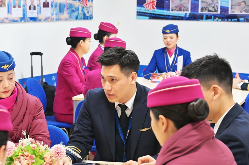 許航和楊曌分別與班組同事進行航前準備工作。鄒樂攝