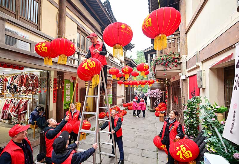 志愿者為黃葛古道敦厚坡老街的傳統民居掛燈籠。郭旭攝