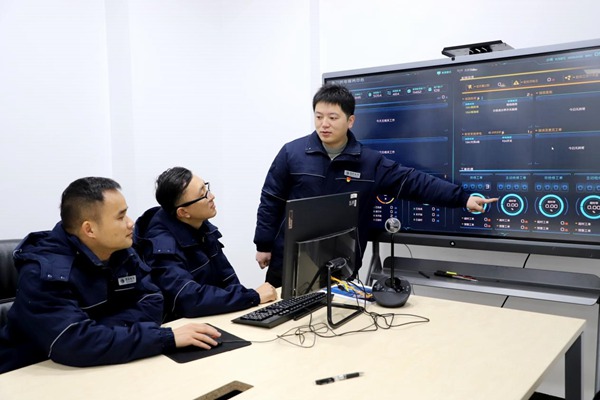程政（右一）與同事研討電力大數據問題。國網永川供電公司供圖