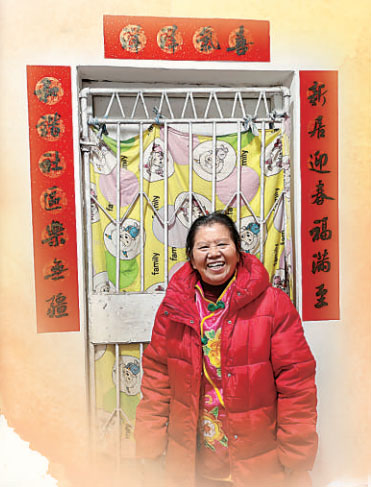 貼好春聯，彭其碧笑意盈盈。陳翔攝