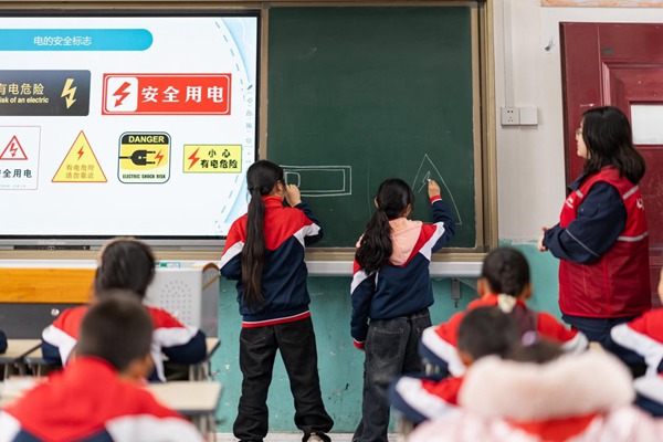 志愿者和學生們繪畫電力警示標志。國網重慶永川供電公司供圖