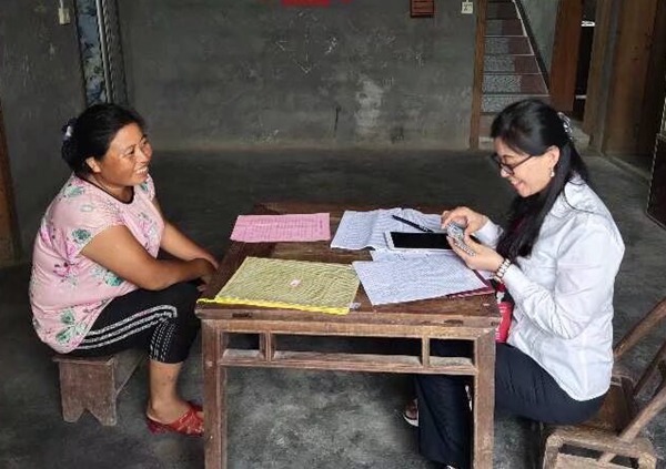 圖為冉力（右）走訪農戶，筆記本上記滿民情，心中裝著萬家燈火。重慶移動供圖