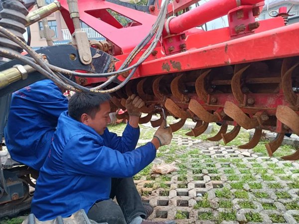 農服墊江公司農機手檢修旋耕機。重慶智慧農服集團供圖