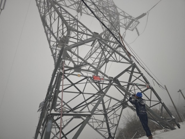 3月28日，國網城口供電公司輸電線路班鄧均華在三排山220千伏華城線237號塔觀察線路覆冰情況。王超攝