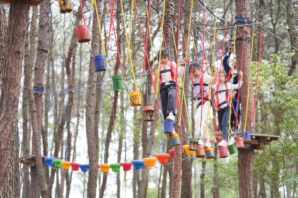 4月6日，北碚區復興街道漫花山田農業公園，孩子們在體驗“叢林飛躍”游樂項目。特約攝影 秦廷富