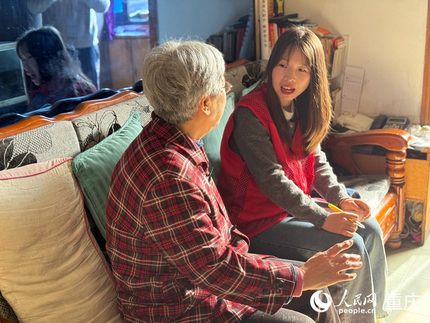 陳春林（右）在居民家中入戶走訪。人民網記者 胡虹攝