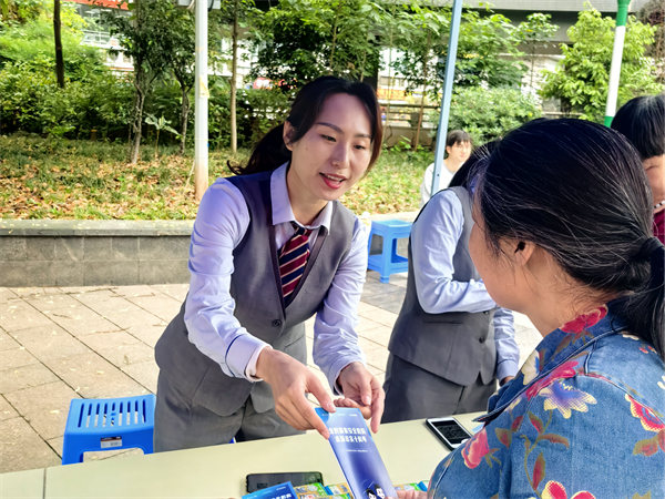 工作人員向老人發放反詐手冊。重慶電信供圖