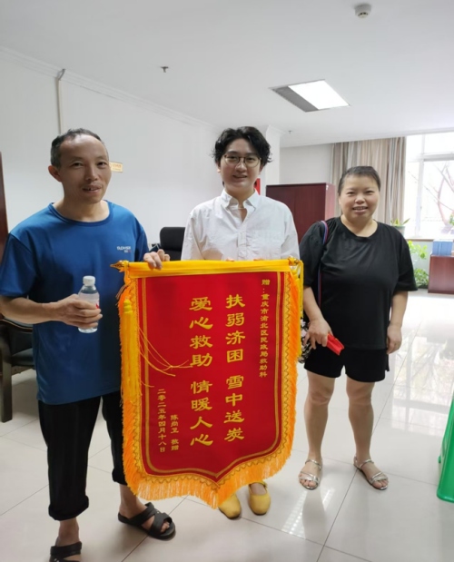 陳尚衛為渝北區民政局救助科工作人員送上錦旗。渝北區民政局供圖