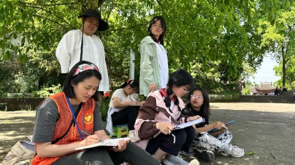 志愿者帶領游客親手描繪石刻。大足石刻研究院供圖