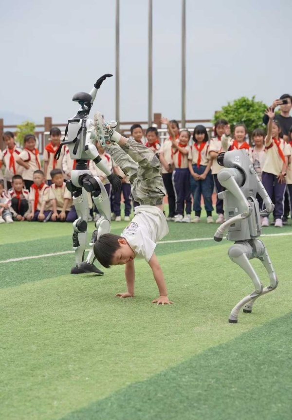 小朋友與機器人“斗舞”。甘國平攝