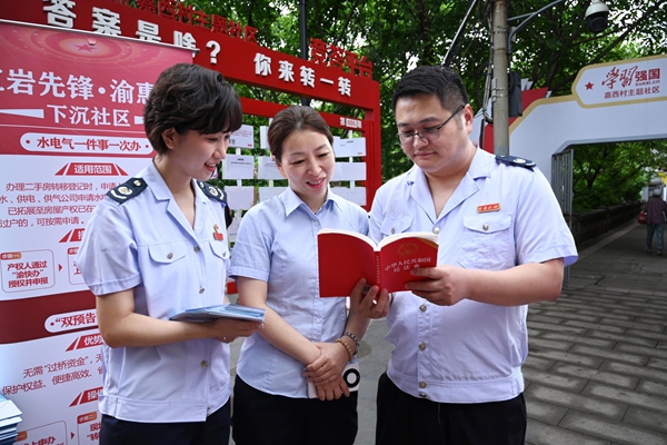 稅務總局駐重慶特派辦和渝中區稅務局工作人員在嘉西村主題社區為市民介紹民法典相關內容。徐佑君攝