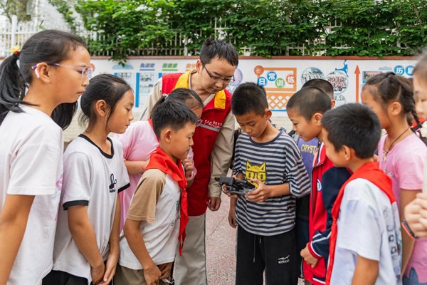 青年志愿者指導學生們體驗無人機操作。國網重慶永川供電公司供圖