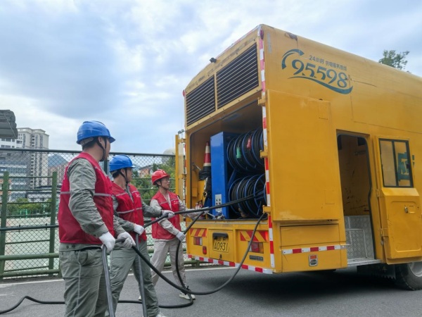 國家電網重慶電力（城口綜合）紅巖共產黨員服務隊隊員在城口中學施放中壓電源車電纜，為接入2025年高考考點線路做準備。國網城口供電公司供圖