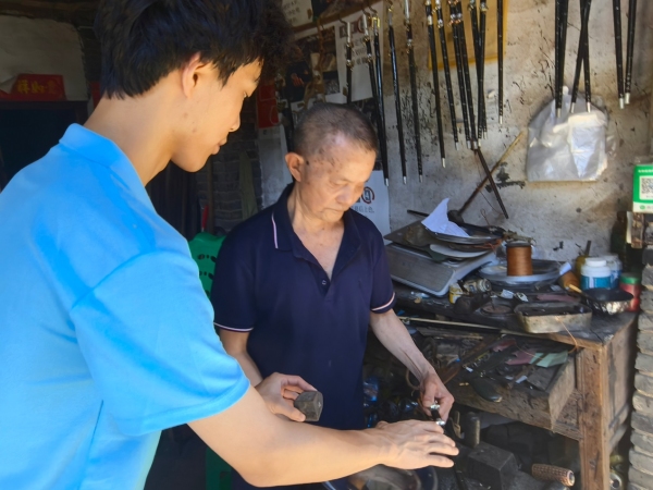 服務隊成員采訪手工木秤制作者王澤喜老人。重慶財經學院供圖