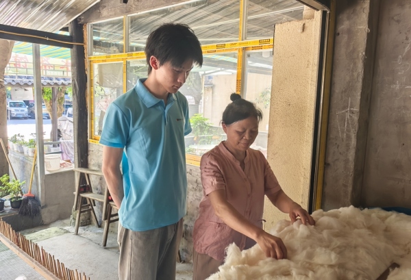 服務隊成員采訪棉被手藝人。重慶財經學院供圖