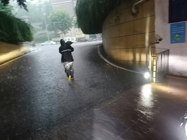 招商依云江灣物業工作人員正緊急運送防汛沙袋封堵車庫入口，防止雨水倒灌。招商積余重慶公司供圖