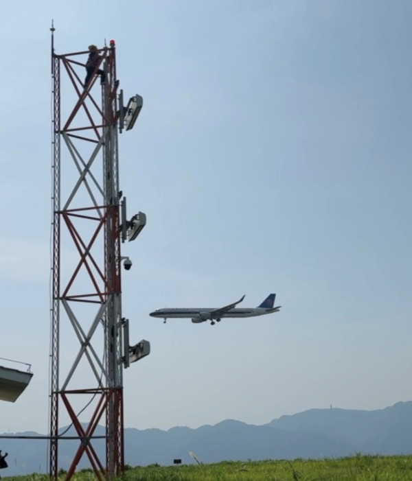 李遠望在下滑天線塔架上開展例行檢修。朱雋攝