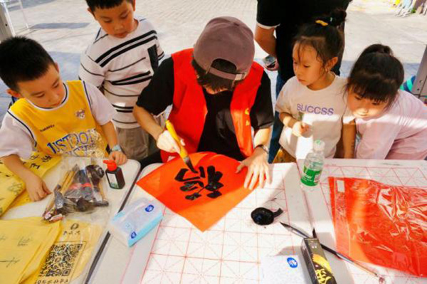 實踐團成員帶領孩子們學寫“?！弊?。重慶電力高等?？茖W校經濟管理學院供圖