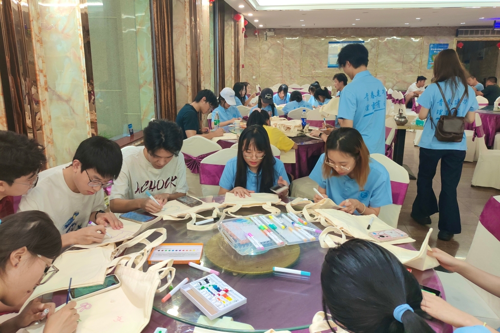 實踐團成員在帆布包上精心繪制圖案。重慶理工大學供圖
