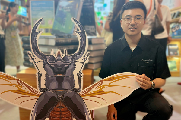 《中國鍬甲大圖鑒》作者詹志鴻在書博會重慶大學出版社展位與讀者交流。重慶大學出版社供圖